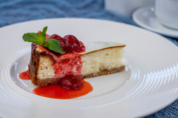 Classic cheesecake with strawberry and mint on white plate