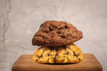 Delicious handmade chocolate chip cookies on a wooden cutting board on gray background