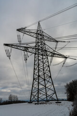 Hochspannungsmasten vor wolkigem Himmel