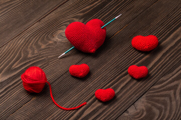 red knitted hearts on wooden background