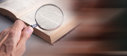 looking at a book through a magnifying glass