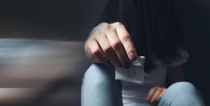 a drug addict holds a bag of powder