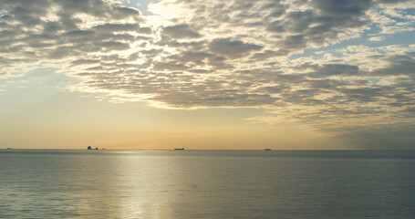 Beautiful sea horizon sky shining sunset clouds in majestic nature background.