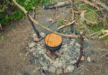 Cooking in field conditions, boiling pot at the campfire