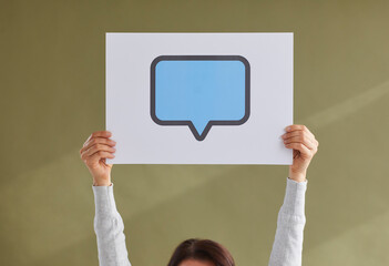 Anonymous young girl showing one rectangle blue mockup copyspace cardboard speech bubble on green background. Female hands holding up paper reply message icon with free, blank, clean space for text