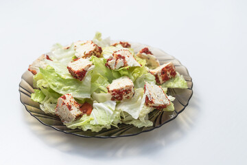 Healthy food. Iceberg lettuce with white cheese on a plate. The plate is on a white background.
