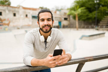 Portrait of a latin man texting outdoors