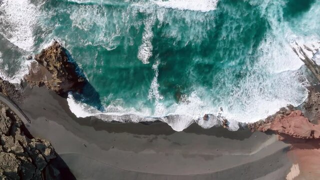 Playa el Golfo top view near the El Lago Verde Lake. Lanzarote Island. Canary Islands. Spain. Atlantic ocean beach. Green lake of volcano origin in the mountains. Aerial view