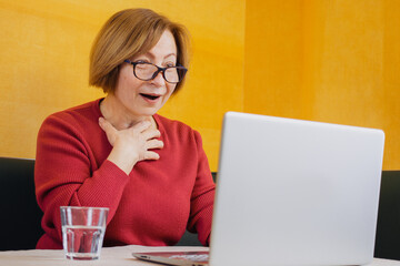 Emotional happy senior woman making online video call looking at smartphone, having conversation using app for communication sitting at home .Talking with with children grandchildren far abroad