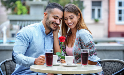 Red rose for a girlfriend. Romantic couple in the cafe. Dating, love, relationships