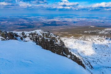 Snowy landscape of mountain trails and hills at cloudy morning