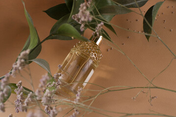 golden perfume bottle lies between the flowers