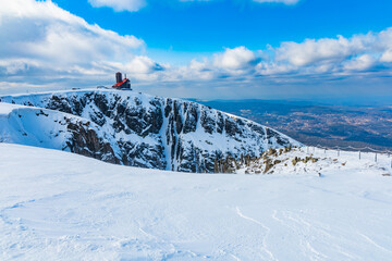 Fototapeta premium Snowy landscape of mountain trails and hills at cloudy morning