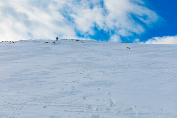 People walk down to the mountain making a new mountain trail full of fresh snow