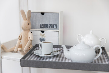 a wooden hare on hinges, a cup of tea and a teapot, a small chest of drawers for rings and small jewelry. Tea drinking. Table decoration for tea ceremony