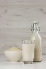 Obraz na płótnie Canvas A bottle and a glass with alternative dairy free rice milk. Lactose free beverage