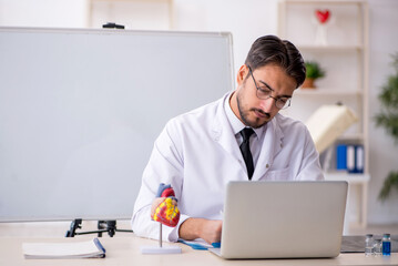 Young male doctor cardiologist sitting in the classroom