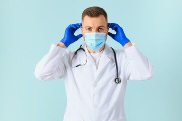 Male doctor in medical mask on color background