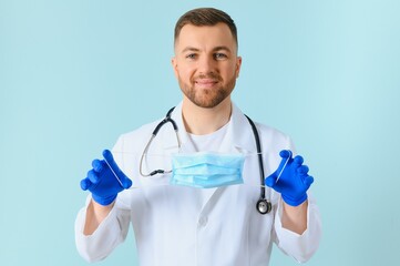 Male doctor in medical mask on color background