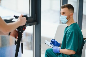 Handsome male doctor recording video for medical blog