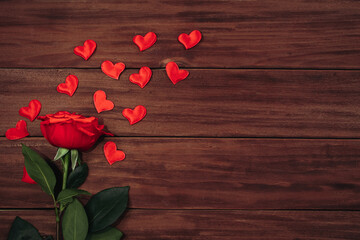 Naklejka na ściany i meble Red rose and hearts on a wooden background. Valentine's day concept, greeting card.