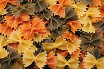 Mix of colored traditional raw uncooked italian butterfly farfalle pasta as a texture background
