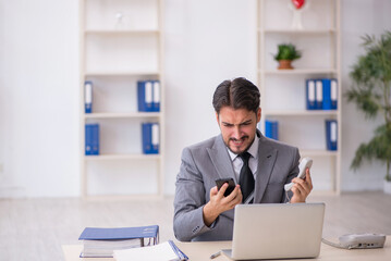 Fototapeta premium Young male employee working in the office