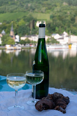 White quality riesling wine served on old bridge across Mosel river with view on old German town in sunny day