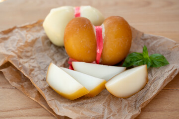 Cheese collection, variety of Italian cow milk cheese scamorza with Italian houses on background