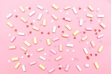 lot of colorful sweet mini marshmallows and heart shaped confetti food. pink background for Valentines day, womens day, birthday, party pattern