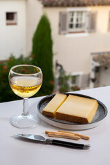 Cheese collection, hard French cheese comte made from  cow milk with rind in Franche-Comte region, France served with white wine