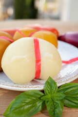 Cheese collection, variety of Italian cow milk cheese scamorza with Italian houses on background