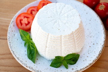 Cheese collection, white Italian soft cheese ricotta served with fresh tomatoes and basil