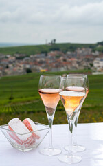 Tasting of white and rose brut champagne wine with view on green pinot noir grand cru vineyards of famous champagne houses in Montagne de Reims near Verzenay, Champagne, France