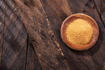 Organic brown sugar in the wooden bowl - Saccharum officinarum