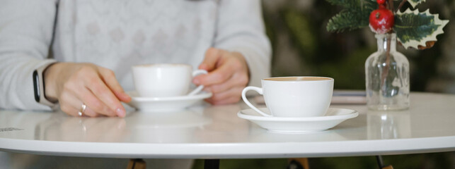 Fototapeta na wymiar Woman drinking coffee in cafe in winter. Dreamy relaxed adult female in her 40s. 