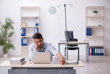 Young male employee suffering at workplace