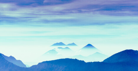 Peaceful image of calm landscape with blue mountains and pale sky