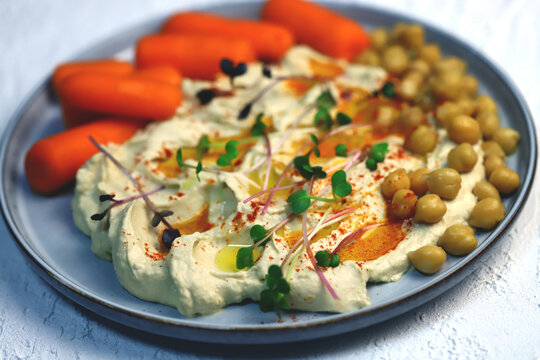 Hummus With Olive Oil And Baby Carrots On A Plate.