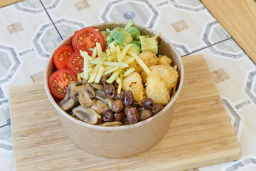 Vegeterian seafood bowl with smoked salmon, shrimp, avocado in take out paper container. Close up, copy space, top view, background.