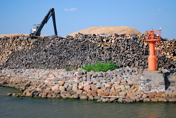 Liepaja, Latvia - May 31, 2011: Port with mole, lighthouse, logs and logging crane.