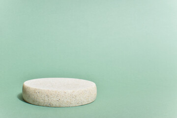 Minimalistic scene of a lying stone on a light green background. Podium for the presentation of...