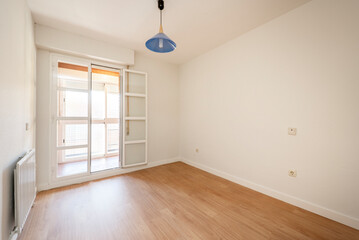 Room with window leading to a closed terrace with glass and wooden floors