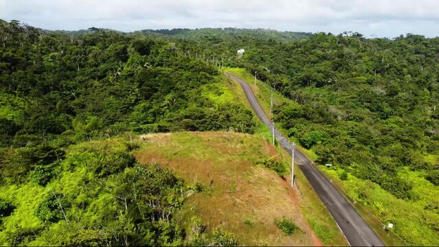 aerial shot in the jungle on the sunny clean road to the mountains inside the guna yala park, Panama (San Blas)