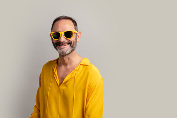 Stylish senior man wearing yellow shit and smiling