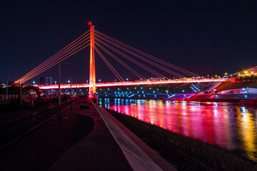 Fototapeta na wymiar Beautiful view of the illuminated Bridge of Lovers over the Tura River at dusk, Tyumen, Russia 