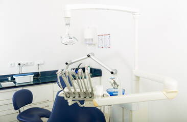 Interior of modern dental practice room with chair, lamp, display and stomatological tools