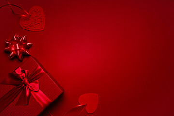 Red box with red ribbon, hearts on a red background, a romantic valentine's day gift for lovers.