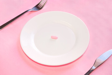 Pill on plate with knife and fork, concept of pharmaceutical addiction