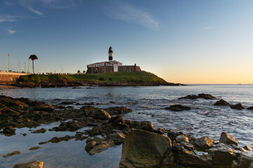 Pôr do sol no Farol da Barra, arquitetura histórica em Salvador, Bahia, Brasil. © phaelshoots